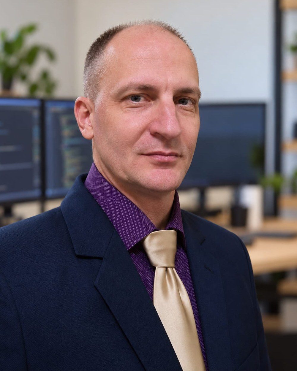 Madár Mihály öltönyben, irodai portré